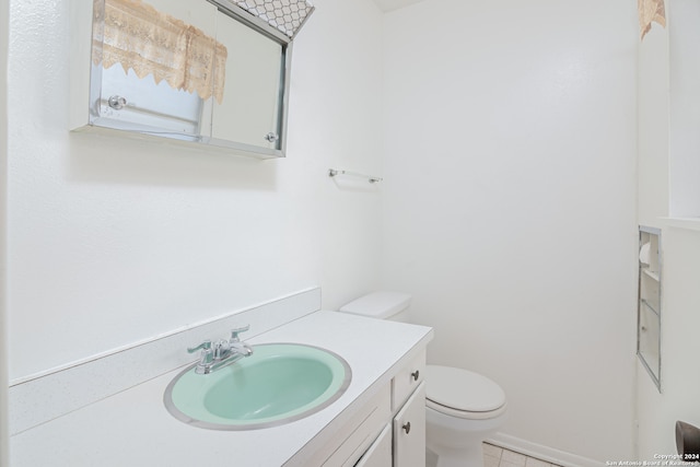 bathroom with tile patterned flooring, vanity, and toilet