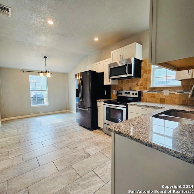 3023 Greenacres St, San Antonio, TX 78230 - kitchen with stainless steel appliances, light stone counters, plenty of natural light, tasteful backsplash, and a textured ceiling
