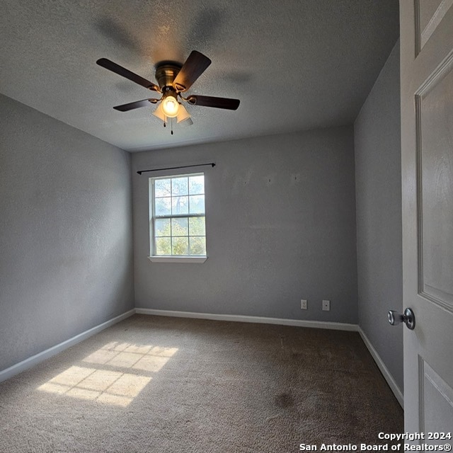 spare room featuring a textured ceiling, carpet floors, and ceiling fan