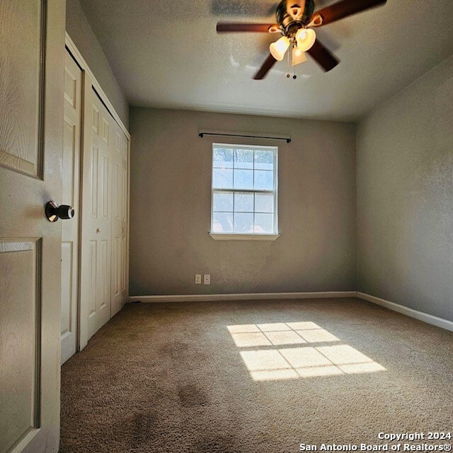 unfurnished bedroom featuring ceiling fan, a textured ceiling, and carpet floors