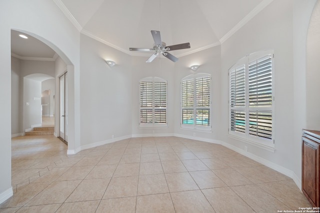 spare room featuring ceiling fan, vaulted ceiling, light tile patterned floors, and ornamental molding