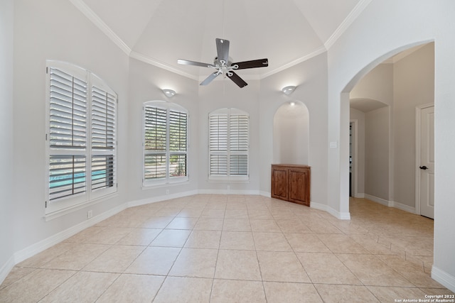 spare room with ceiling fan, high vaulted ceiling, light tile patterned floors, and crown molding