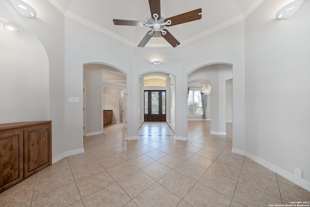 tiled entrance foyer featuring ceiling fan and crown molding