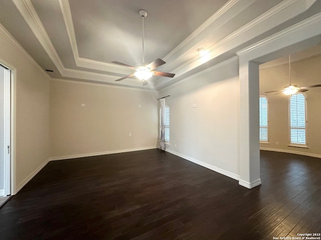 unfurnished room featuring ceiling fan, dark hardwood / wood-style floors, a raised ceiling, and ornamental molding