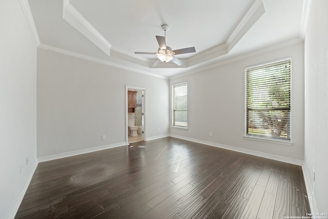 spare room with ceiling fan, a tray ceiling, dark hardwood / wood-style floors, and crown molding