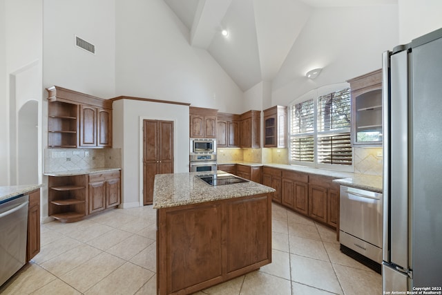 kitchen featuring high vaulted ceiling, decorative backsplash, appliances with stainless steel finishes, and a center island