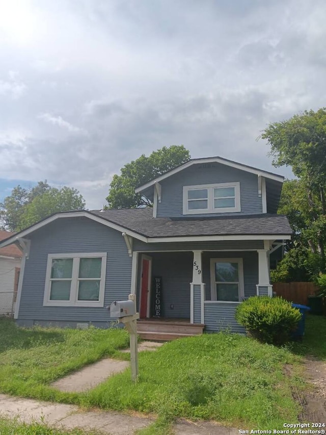 view of front of property with a porch and a front yard