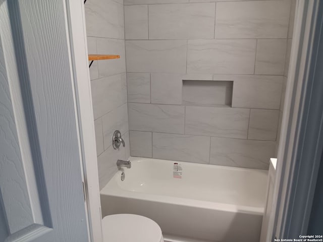 bathroom with tiled shower / bath and toilet