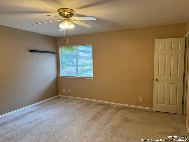 carpeted spare room featuring ceiling fan