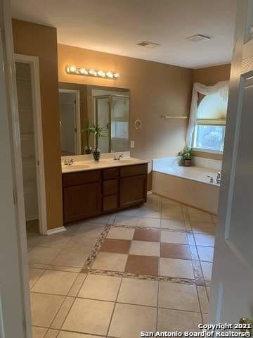 bathroom with vanity, tile patterned floors, and a tub