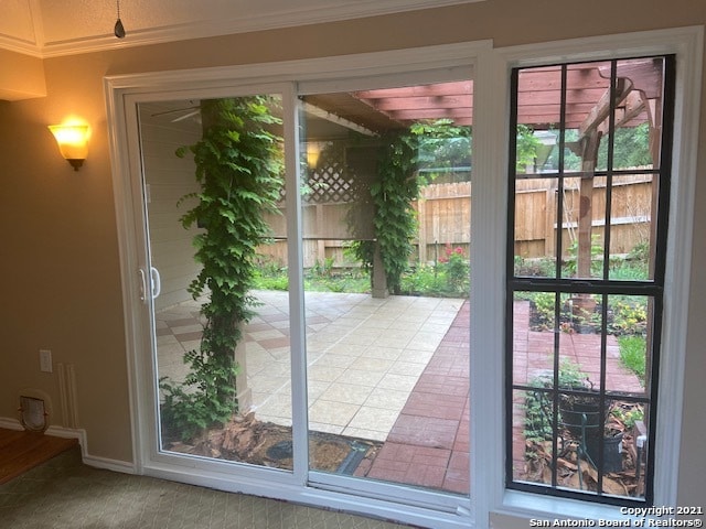 entryway featuring a wealth of natural light, carpet flooring, and ornamental molding