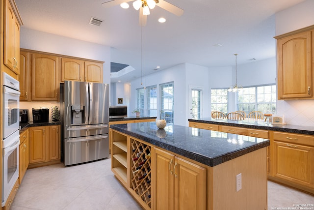 kitchen with dark countertops, visible vents, appliances with stainless steel finishes, and a center island