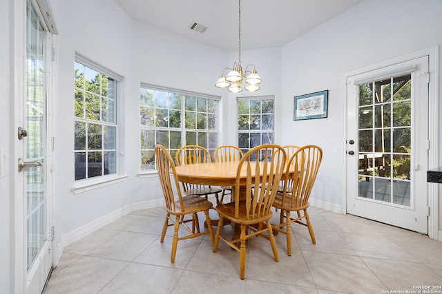 tiled dining room with a wealth of natural light and a notable chandelier