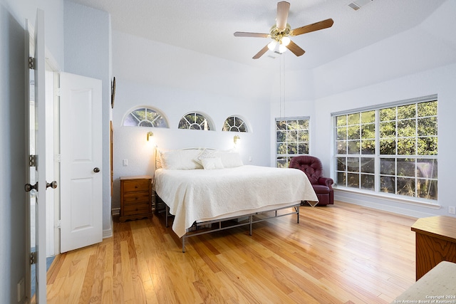 bedroom featuring ceiling fan, light hardwood / wood-style floors, and high vaulted ceiling