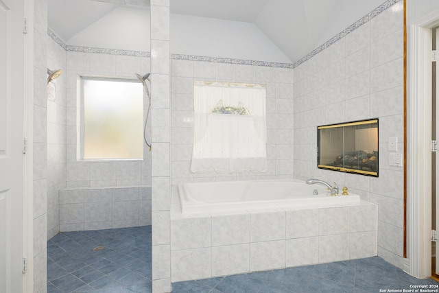 bathroom featuring vaulted ceiling, a garden tub, tile patterned floors, and a tile shower