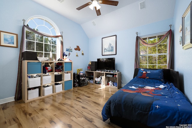 bedroom with visible vents, multiple windows, wood finished floors, and vaulted ceiling