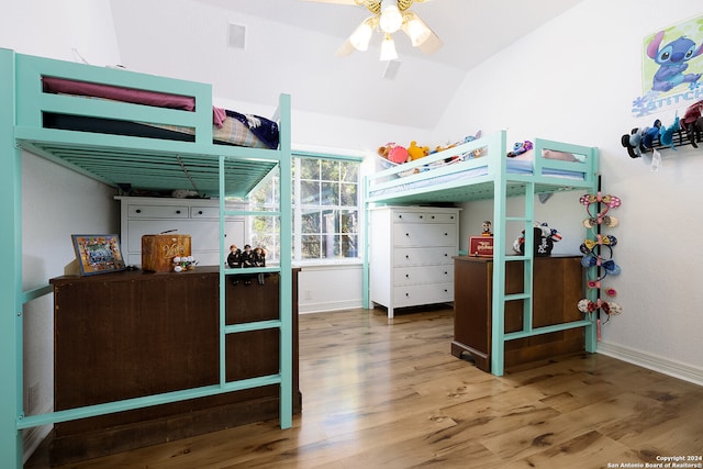 bedroom featuring visible vents, baseboards, wood finished floors, and vaulted ceiling