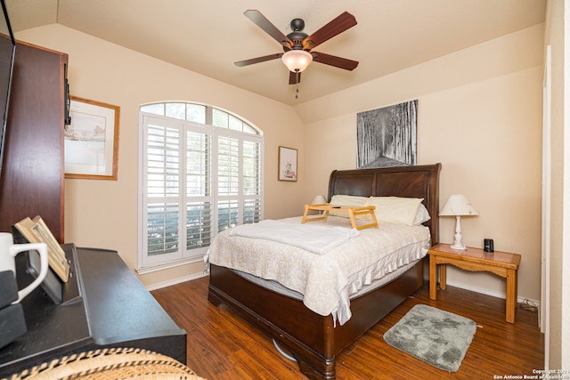 bedroom featuring dark hardwood / wood-style flooring, vaulted ceiling, and ceiling fan