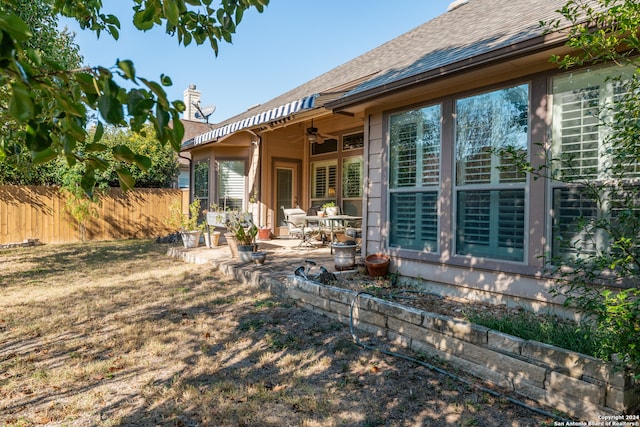 rear view of property with ceiling fan and a patio