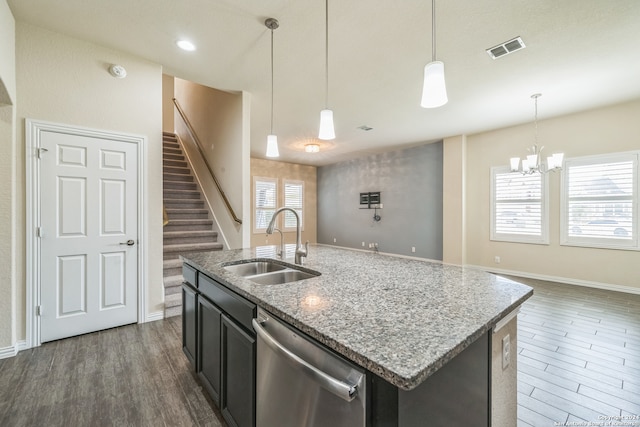 kitchen featuring dark wood-type flooring, a center island with sink, dishwasher, sink, and decorative light fixtures