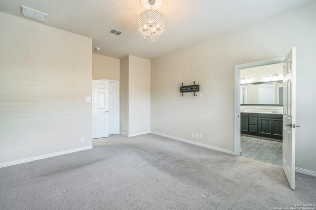 12009 Vignette, Schertz, TX 78154 - unfurnished bedroom with light carpet, baseboards, a chandelier, and ensuite bath
