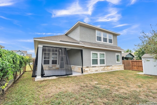 rear view of house featuring a yard, a patio, and a storage shed