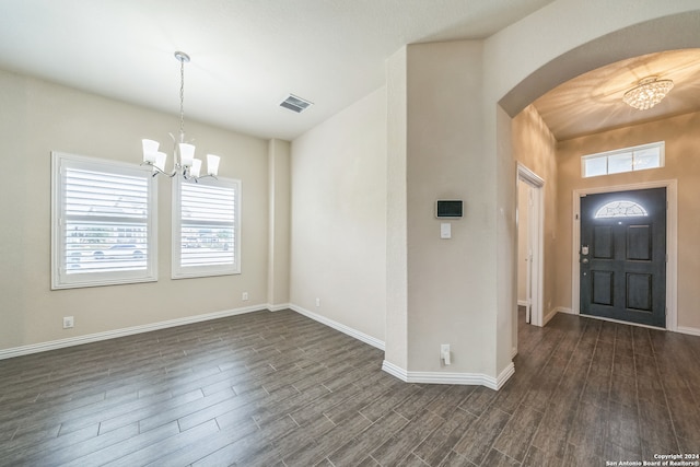 foyer entrance featuring dark hardwood / wood-style flooring and a notable chandelier