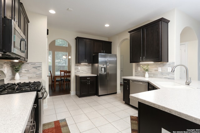 kitchen featuring stainless steel appliances, light tile patterned flooring, sink, and tasteful backsplash