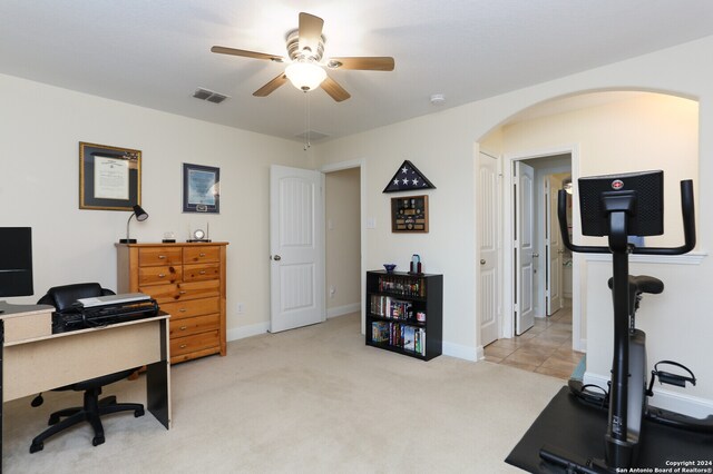 carpeted office space with ceiling fan