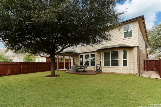 back of property with a yard and a patio area