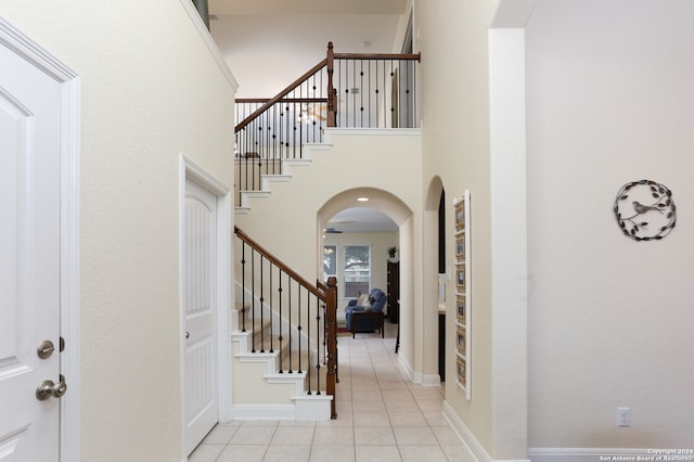 tiled entrance foyer with a towering ceiling