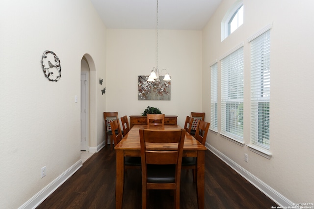 dining space featuring dark hardwood / wood-style floors and an inviting chandelier