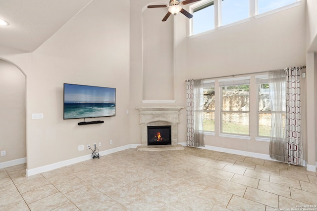 unfurnished living room featuring high vaulted ceiling, ceiling fan, and light tile patterned floors