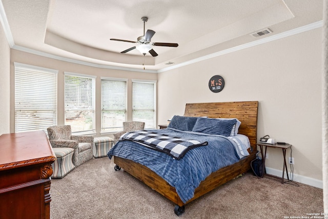 carpeted bedroom with ornamental molding, ceiling fan, and a tray ceiling