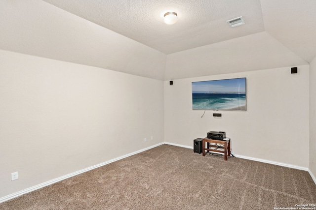 unfurnished living room featuring lofted ceiling, a textured ceiling, and carpet flooring