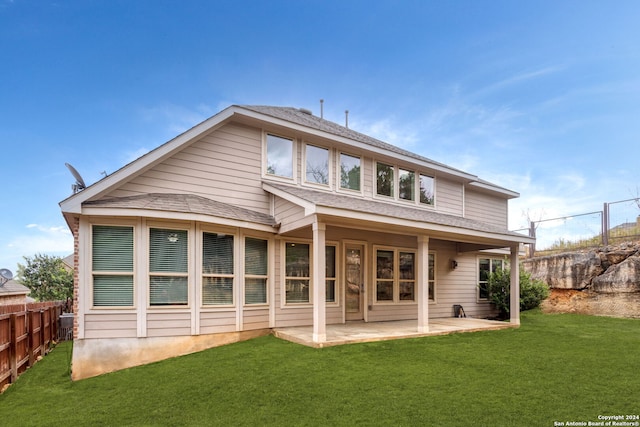 rear view of house with a yard and a patio area