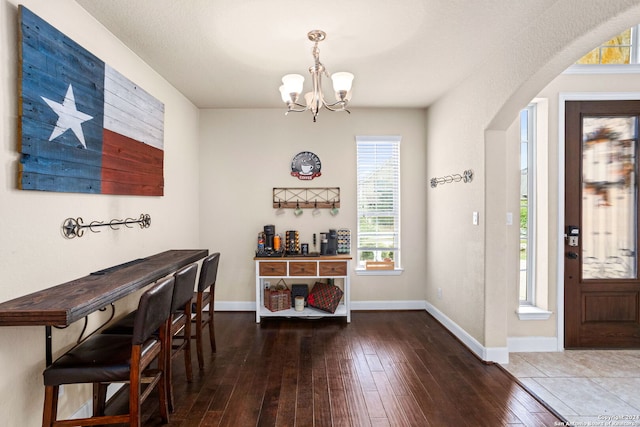 dining area with hardwood / wood-style floors and a chandelier