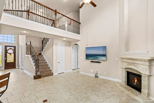 unfurnished living room featuring a towering ceiling and a high end fireplace