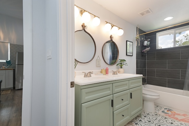 full bathroom featuring wood-type flooring, toilet, vanity, and tiled shower / bath