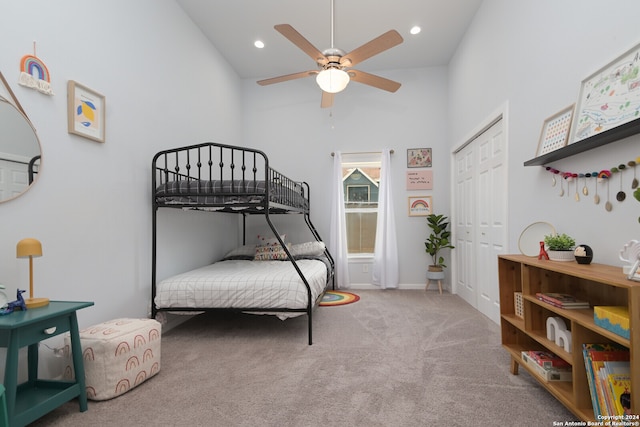 carpeted bedroom featuring ceiling fan, a closet, and high vaulted ceiling