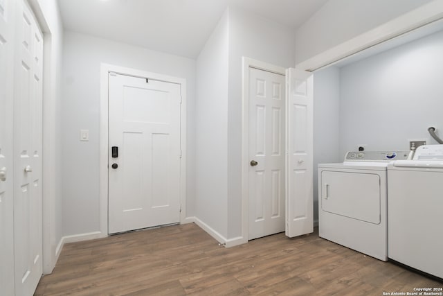 laundry room with hardwood / wood-style flooring and washer and clothes dryer