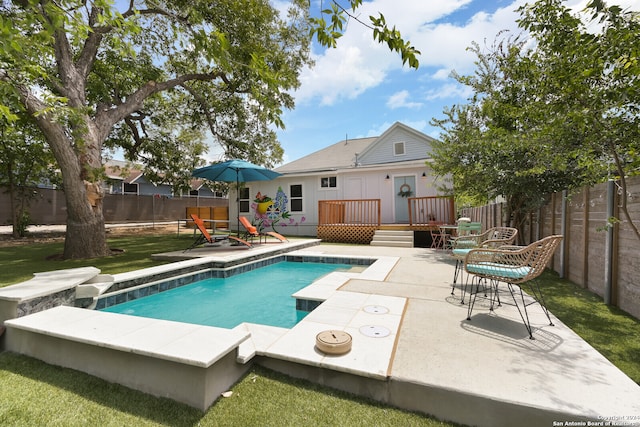 view of swimming pool with a deck, a lawn, and a patio area