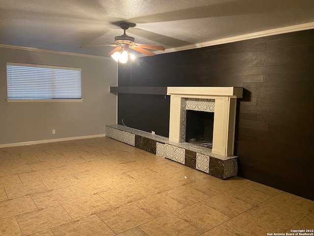 unfurnished living room featuring ornamental molding, a textured ceiling, ceiling fan, and a fireplace