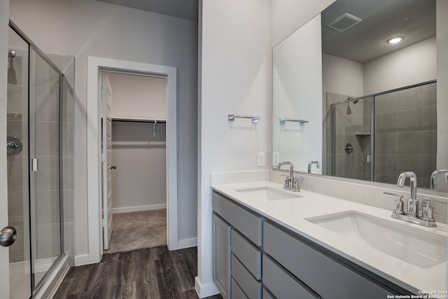 bathroom with walk in shower, vanity, and hardwood / wood-style floors