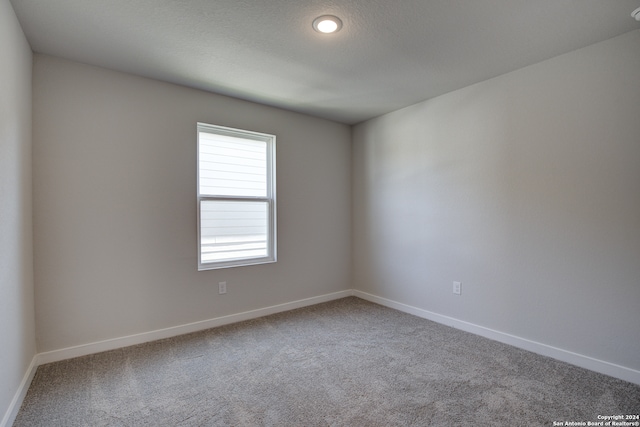 spare room with a textured ceiling and carpet floors