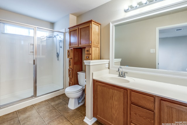 bathroom with toilet, vanity, an enclosed shower, and tile patterned flooring