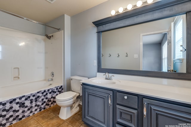 full bathroom with toilet, tiled shower / bath combo, vanity, and tile patterned flooring