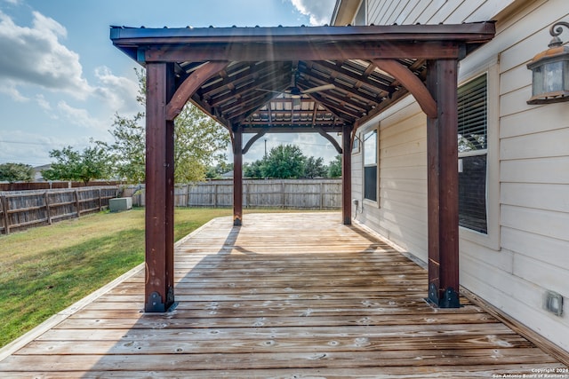 wooden terrace with ceiling fan, a yard, and a gazebo