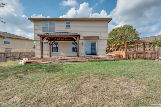 rear view of house featuring a lawn, a wooden deck, and a gazebo