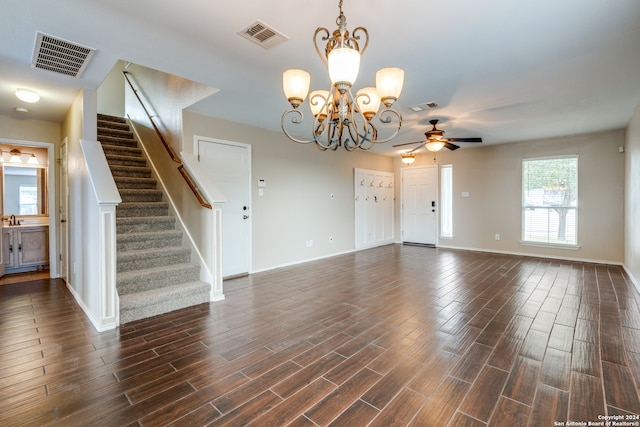 unfurnished living room featuring dark hardwood / wood-style floors and ceiling fan with notable chandelier